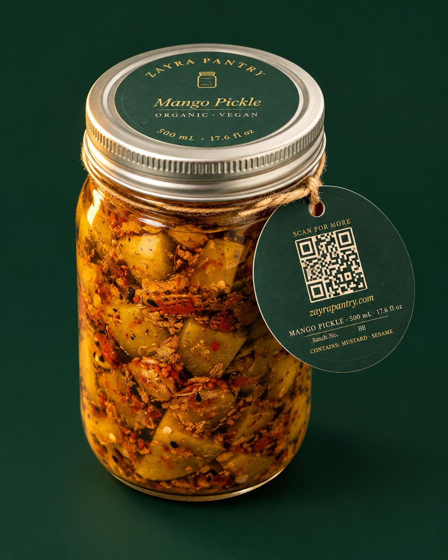 Mango pickle 500 mL jar with hang tag, three-quarter angle, deep green backdrop
